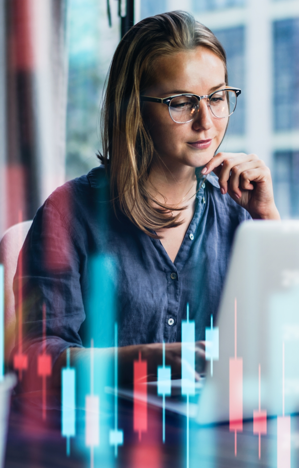 Lady with glasses looking pensively at the screen of a laptop. The image has a virtual background of bar charts.