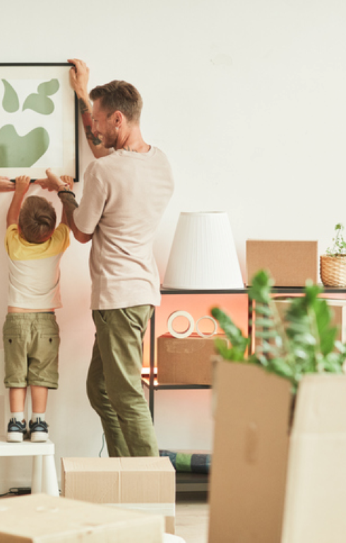 kids helping dad put up a frame on the wall