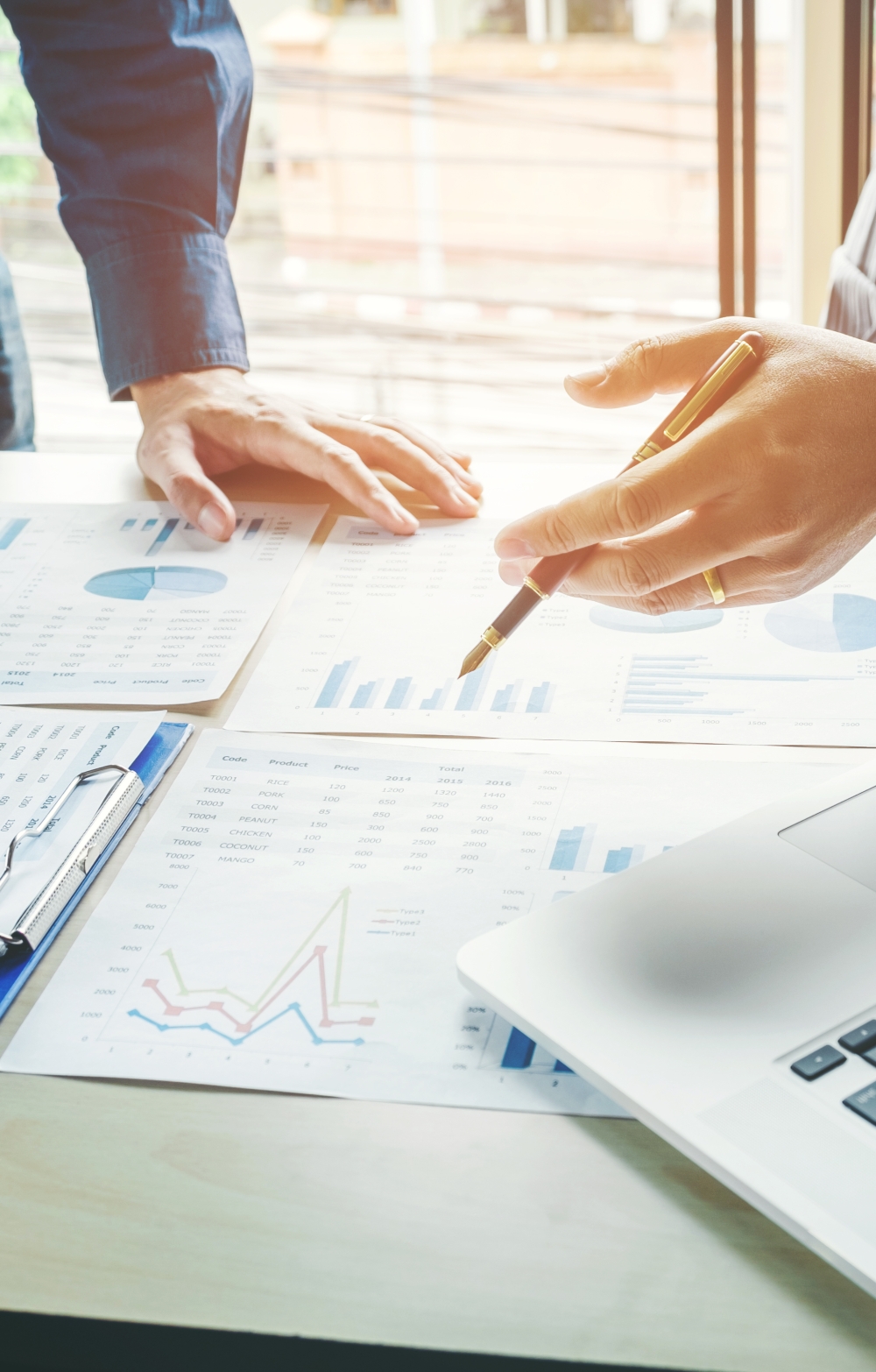 picture of two men talking over a table with documents