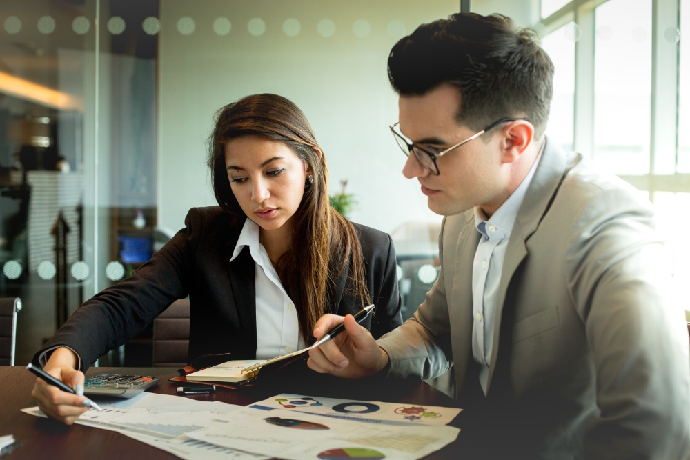 2 people examining a document carefully