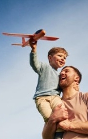father and son flying a toy plane