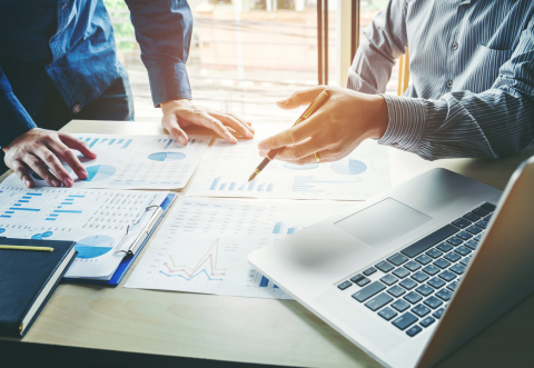 Two people discussing over a laptop