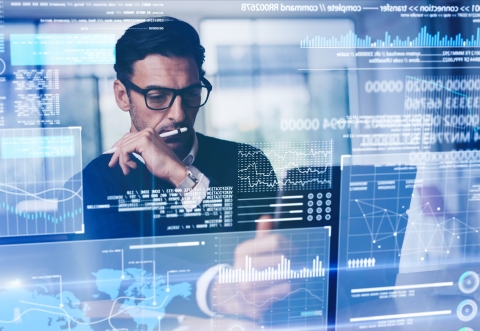 Person looking at a laptop screen with lots of data